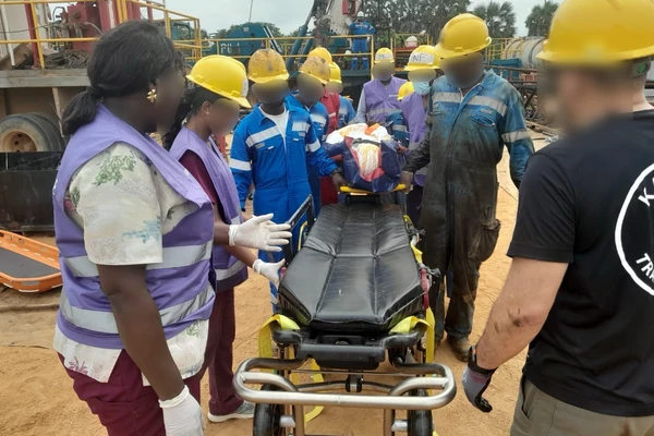 Équipe autour d’un brancard d’ambulance sur un site de forage