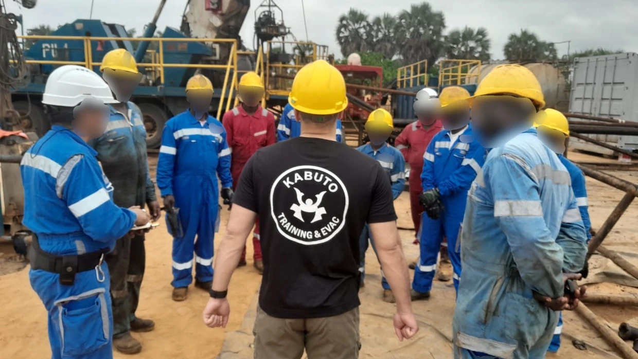 Briefing de l’équipe au pied d’un derrick de forage
