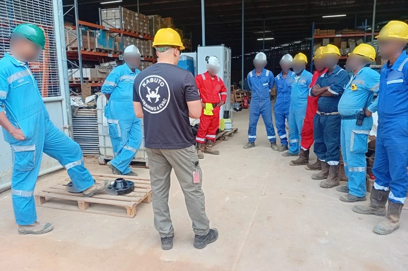 Briefing de l’équipe avant un exercice, dans un entrepôt de site